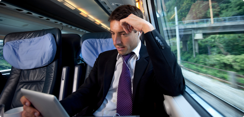Man using a laptop to access world markets with air, land, water transports behind him. 